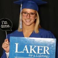 graduating student taking a picture with photobooth props